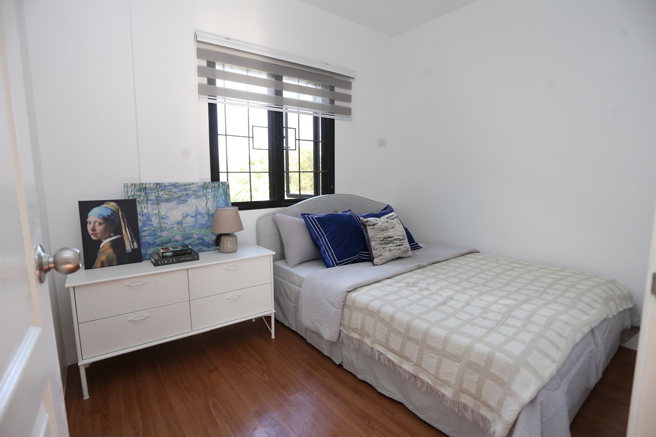 Levana primary bedroom with blue accents and a storage dresser
